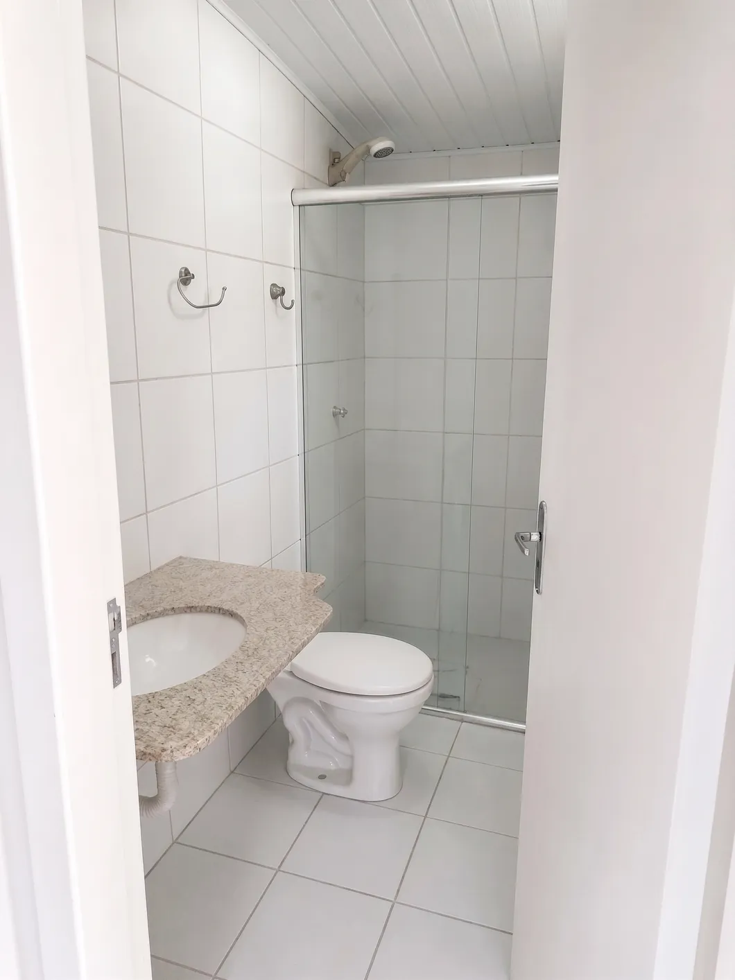 Banheiro da edícula, com box, vaso sanitário e pia instalados.
